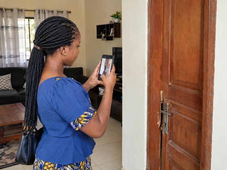 Cliente photographiant une fuite sous son évier avec son téléphone